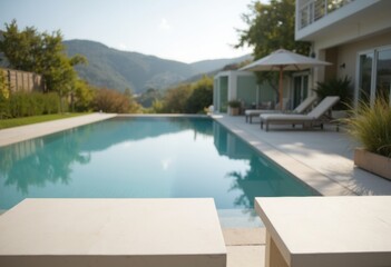 A serene view of a modern poolside with lounge chairs and mountains in the background