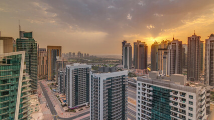 Obraz premium Sunrise view of various skyscrapers and towers in Dubai Marina from above aerial timelapse