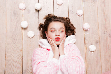 Cute little girl in pajama with sweets sitting on the floor