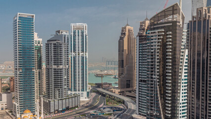 Fototapeta premium View of various skyscrapers and towers in Dubai Marina from above aerial timelapse