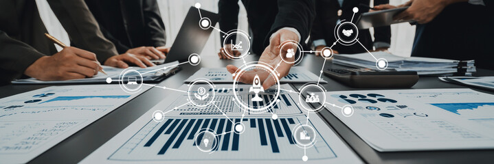 A dynamic business team collaborates on growth strategies using data analytics. Modern technology enhances discussions with visuals on papers and laptops in a vibrant workspace. Amity