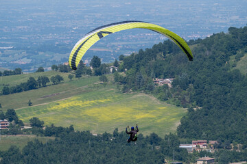 Sestola, Italy – 05 31 2025: Paraglider flies in the air. Aerial view of paragliding. Paraglider...