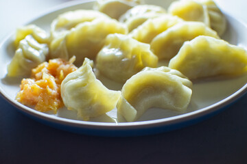 Side view of Momo, type of South Asian dumpling; native to Tibet, Nepal, Bhutan and Sikkim. It is similar to Chinese baozi and jiaozi, Mongolian buuz, Japanese gyoza and Korean mandu.Stock photograph.