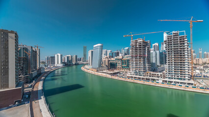 Naklejka premium Skyscrapers near canal in Dubai with blue sky aerial timelapse