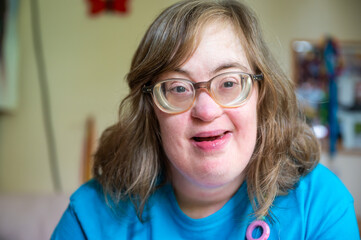 Portrait of a 42 yo happy woman with Down Syndrome in her sleeping room in Tienen, Flemish Brabant...