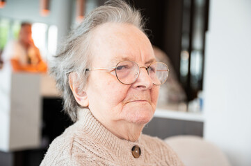 Expressive portrait of an 86 yo grandmother sitting in a wheelchair home in Tienen, Flemish Brabant, Belgium