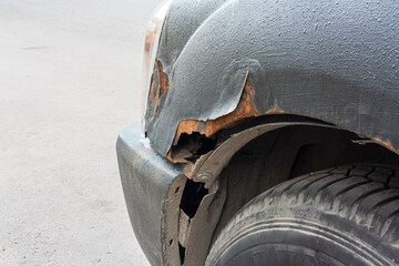 This detailed view closely shows visible rust and significant wear on a cars wheel arch along with...