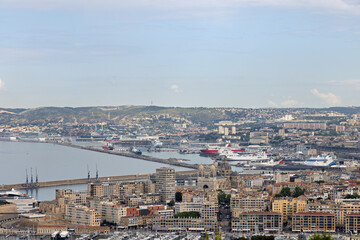 Marina and freight port of Marseilles taken from above with various ships, cruise ship and freighter in spring