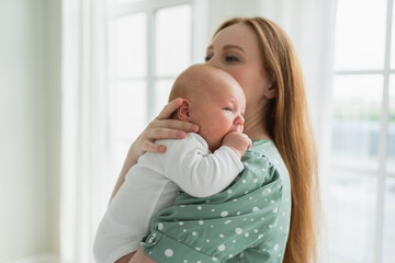 Happy family at home. Mother holding little toddler child daughter. Mom and baby girl relax playing having fun together at home. Mother hugs baby with love care. Mom of breast feeding baby