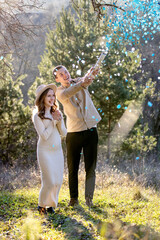Happy couple happily celebrating their pregnancy surrounded by blue confetti