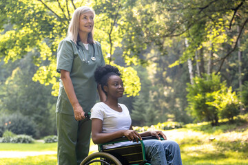 Nurse and a female on a wheelchair in the park