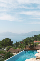 A stunning infinity pool merges with endless ocean views at a luxury hotel, creating a serene...