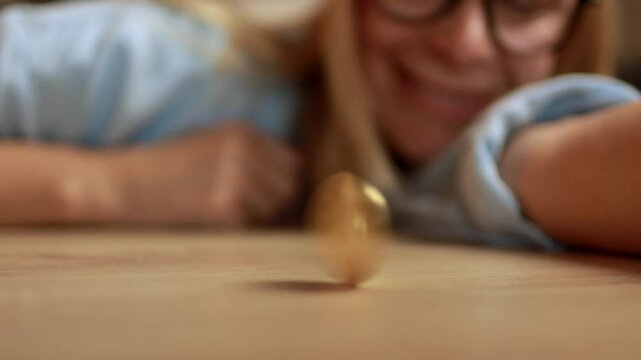 Female investor stopping spinning golden bitcoin on wooden surface. Successful trading, cryptocurrency, crypto currency, bitcoin wallet, digital payment. Cryptocurrency