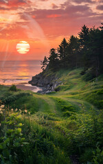 The sun dips below the horizon, casting a warm glow over the coastal path and ocean.