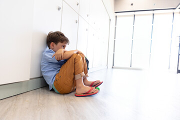 white lockers lining corridor on wood floor, with red flip-flops resting near glass door entrance