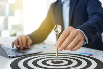 Man with dart aiming at dartboard while working indoors, closeup