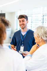 Smiling nurse taking notes while talking with medical team in hospital
