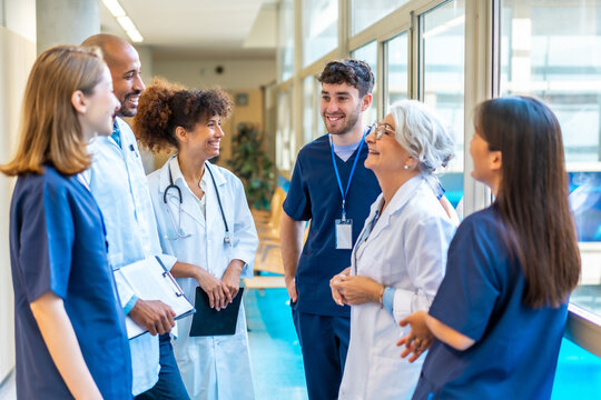 Medical team talking and smiling in hospital corridor