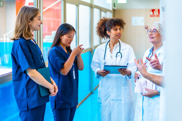 Medical team discussing patient chart in hospital corridor