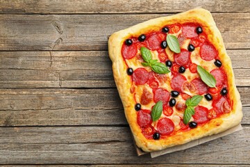 Tasty homemade pizza on wooden table, top view. Space for text