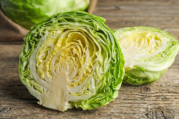 Obraz premium Cut fresh cabbage on wooden table, closeup