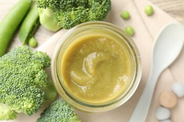 Baby food. Tasty puree in glass jar, ingredients and spoon on table, flat lay