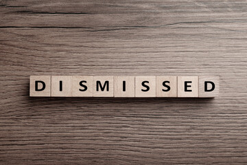 Word Dismissed made of cubes on wooden background, top view