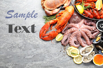 Different sea food on grey table, flat lay. Design with space for text