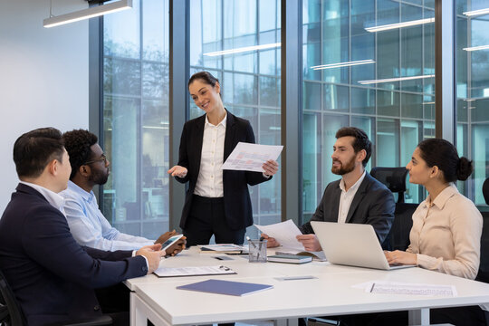 A diverse business team engages in a collaborative discussion during a meeting in a modern office environment.