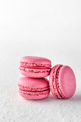 Stack of pink Macarons on white textured background isolated