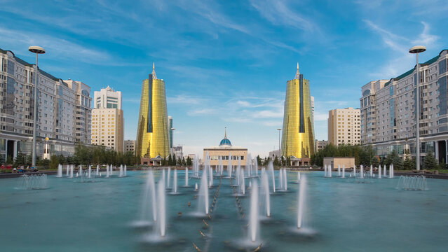 A square in front of Ak Orda with yellow towers timelapse hyperlapse and fountain in the foreground.