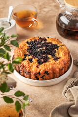 Blueberry cake on a plate on beige background with tea