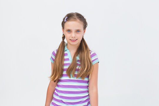 Girl standing in studio wearing pastel-clip side plaits and striped lavender mint polo shirt