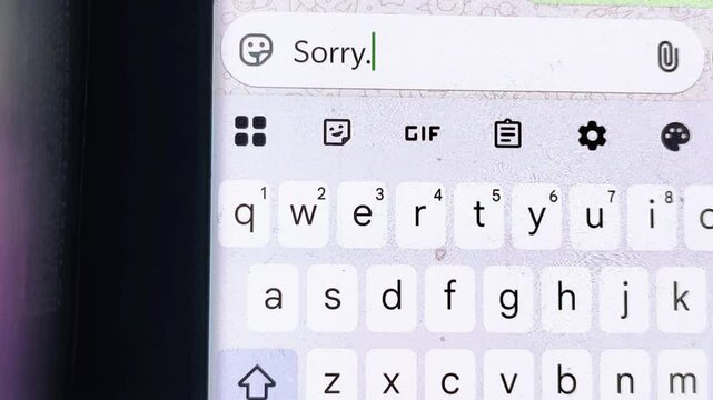 A message on a mobile phone spelling I am sorry. Typing sorry sms. 