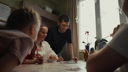 Happy family playing cards together at home during the holidays.