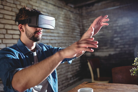 Virtual reality headset resting on table in brick loft workspace with coffee cup and potted plant