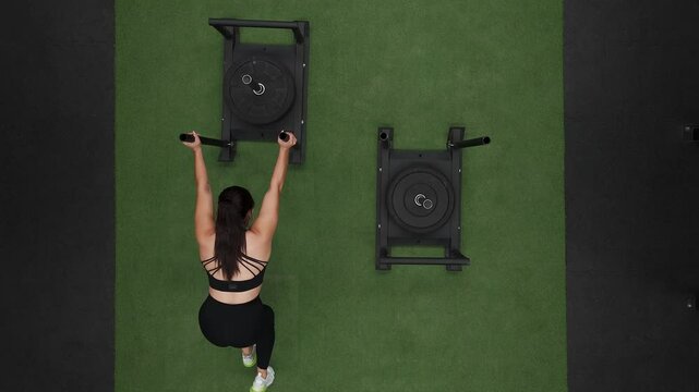 Mexican athlete performing sled push exercise in gym