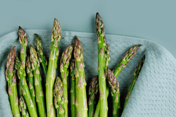 Macro view of fresh wet asparagus wrapped in a clean kitchen towel showing kitchen prep process