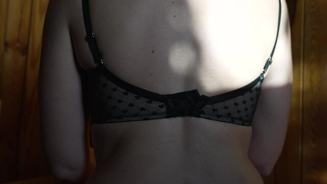 Woman back bra woman back wearing black bra with heart pattern against wood