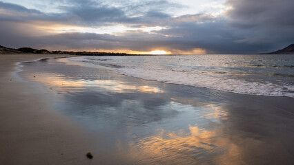 Sunset reflecting on wet sand of famara beach, lanzarote, canary islands, spain © Sebastian