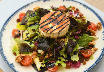 Salad with grilled goat cheese, walnuts, cherry tomatoes and lettuce