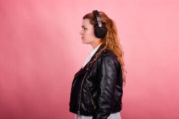 Woman with headphones, listening to music, fashion model in studio posing, music genre, smiling,...