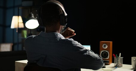 African american analyst works on accounting analysis while he is dancing, feeling the rhythm and...