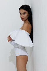 woman sport fitness in white workout outfit standing sideways with long black hair, healthy...