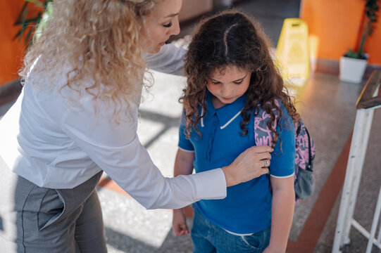 Teacher comforting sad student at school