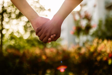 Multiracial young people holding hands showing love outside