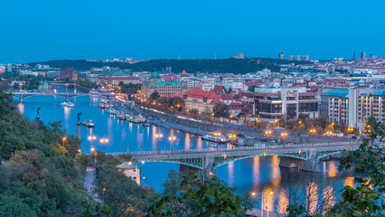Fototapeta premium Aerial evening view of the Vltava River and illuminated bridges day to night timelapse, Prague
