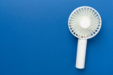 Mini electric fan on color background, top view
