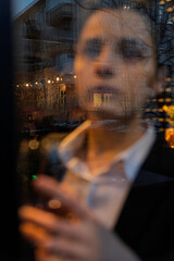 Young woman holding a wine glass in front of the window