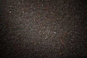 pClose-up view of a dark porphyry slab with a grainy and rough texture. Ideal for backgrounds.